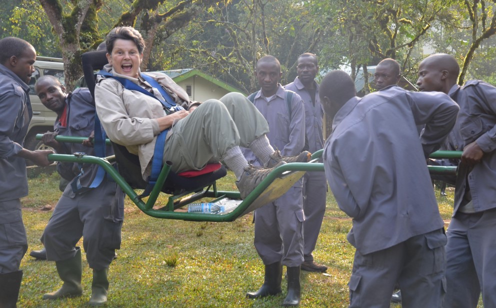 An elderly woman being carried on a Gorilla trekking safari